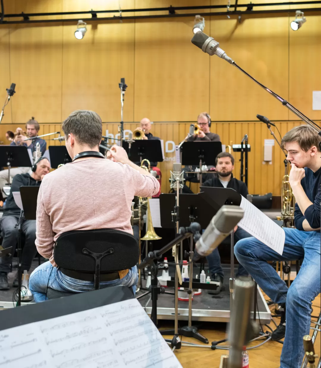 Zwei Studenten im MA Bigband mit dem Schwerpunkt "Leiten" proben mit der hr-Bigband und leiten diese.
