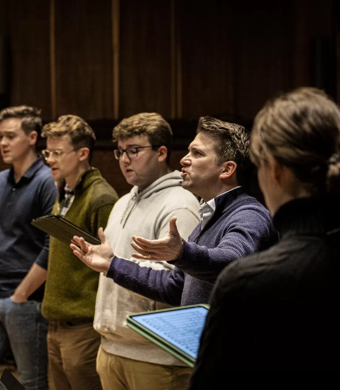 Fünf Sänger*innen und Chorleiter in einer Probe.