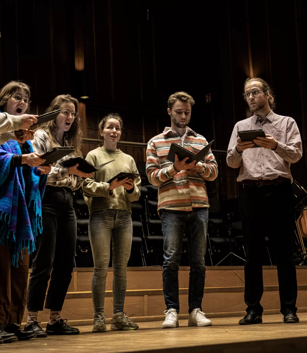 Vokalensemble mit 7 Sänger*innen auf der Bühne des Großen Saals während einer Probe.