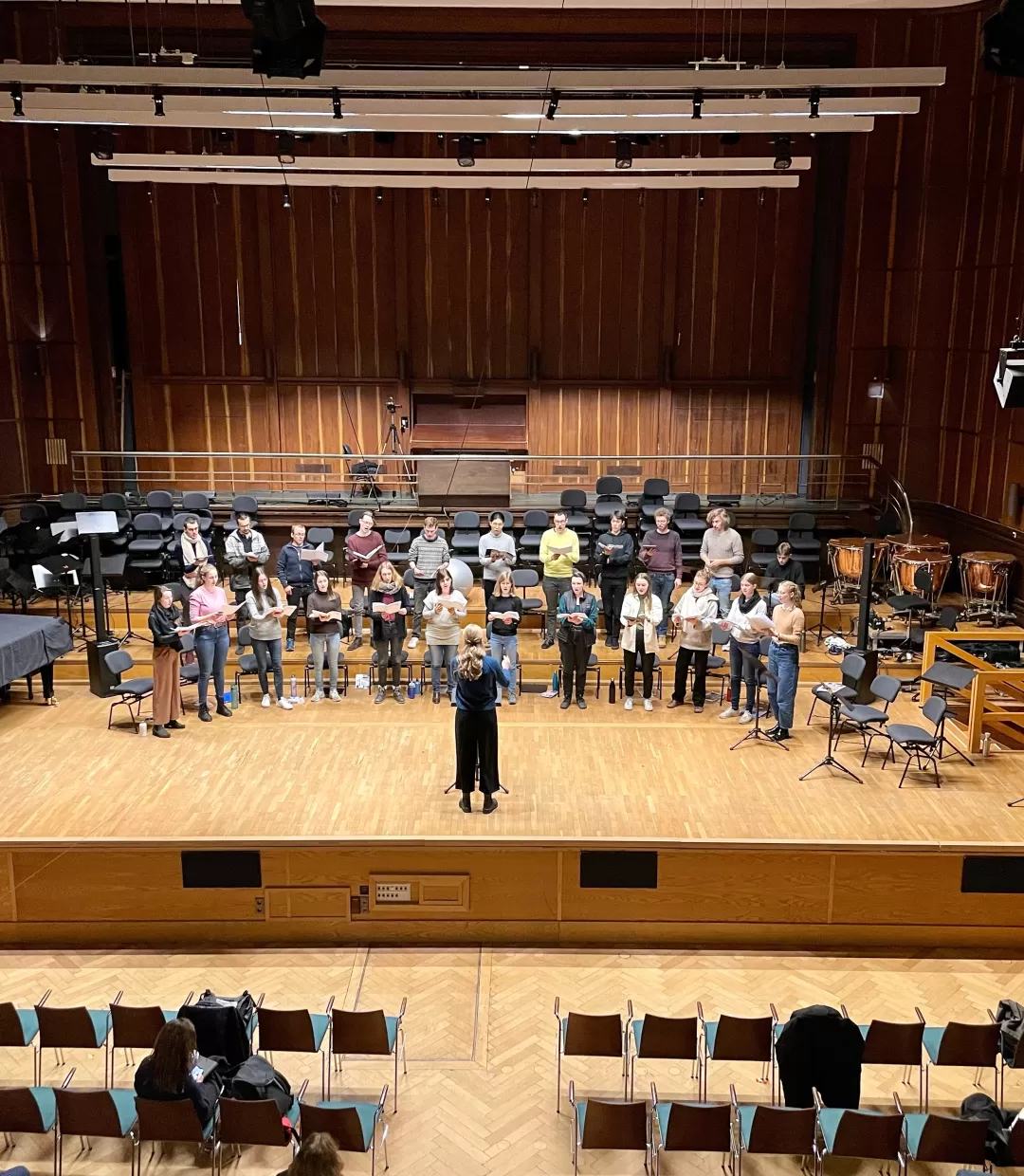 Der Kammerchor probt auf der Bühne, Barney von Voces8 schaut zu