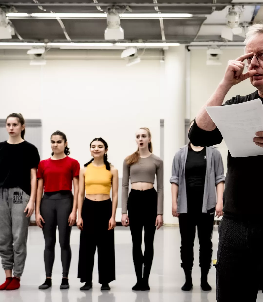 Szene aus dem Tanzunterricht, vier Studierende stehen in einer Reihe im Hintergrund. Im Vordergrund Prof. Dieter Heitkamp.