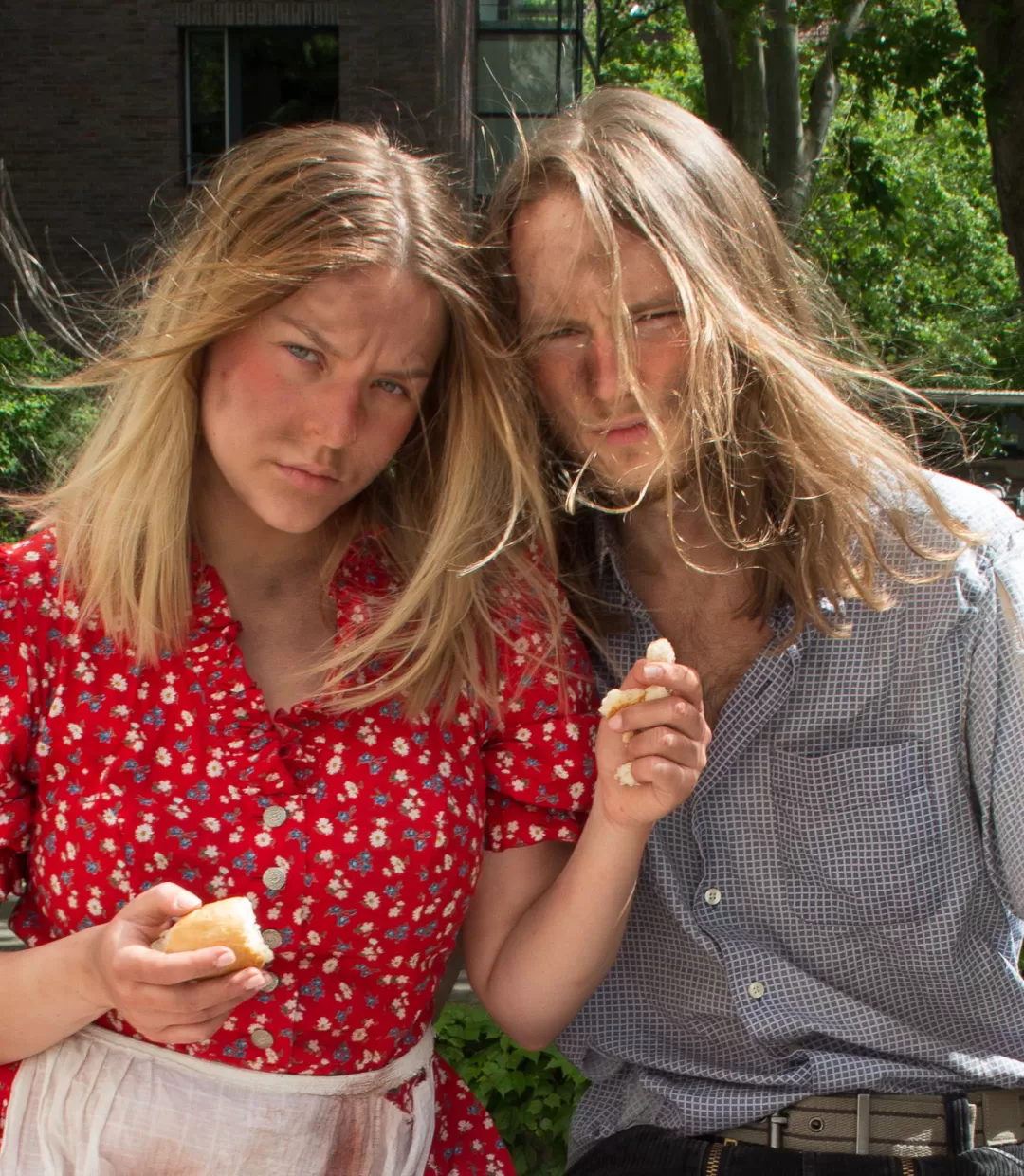 Zwei Studierende mit Brötchen in den Händen und verschmutzten Gesichtern.