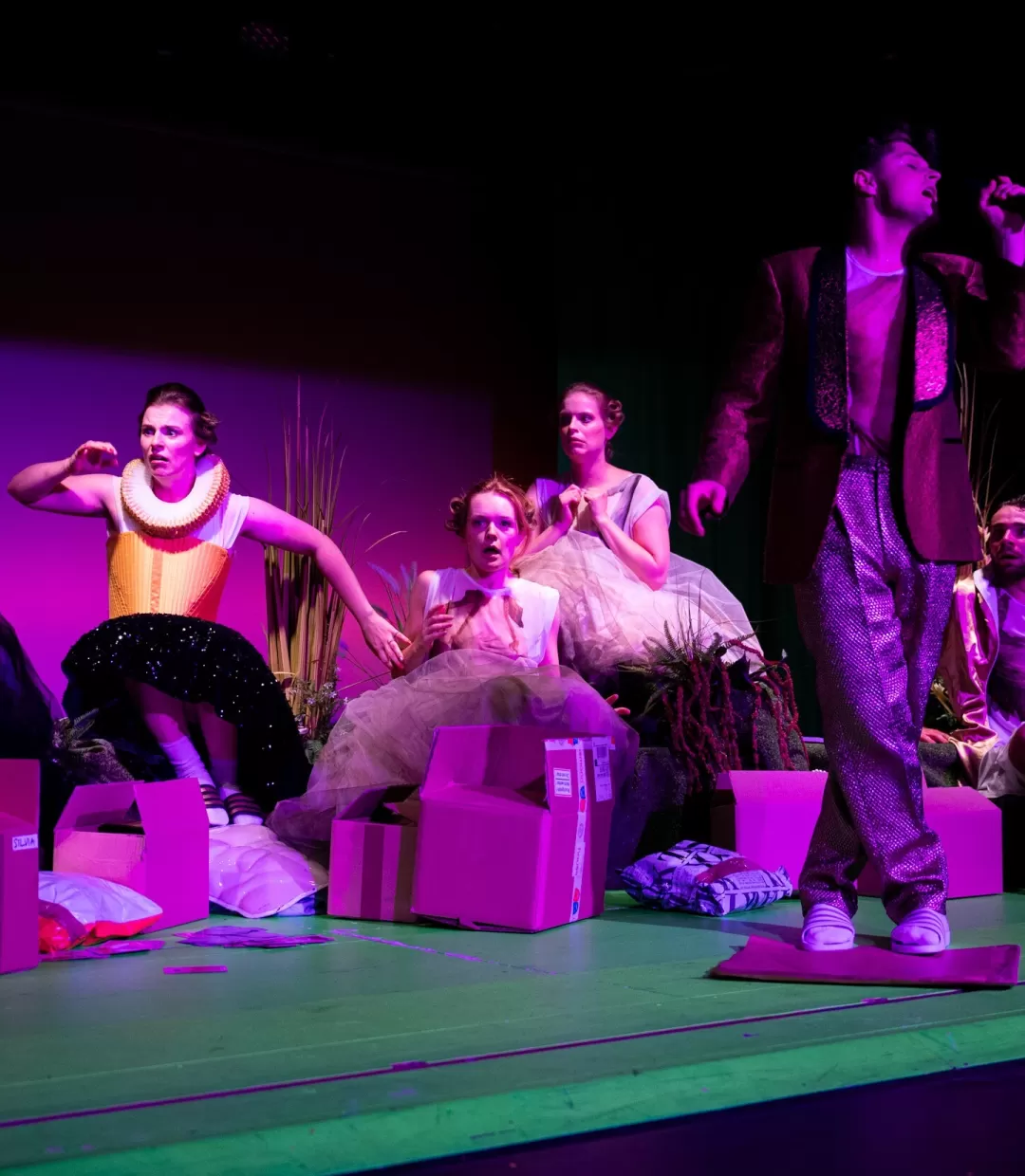 Gruppe mit entsetzer Mimik in violettem Bühnenlicht.