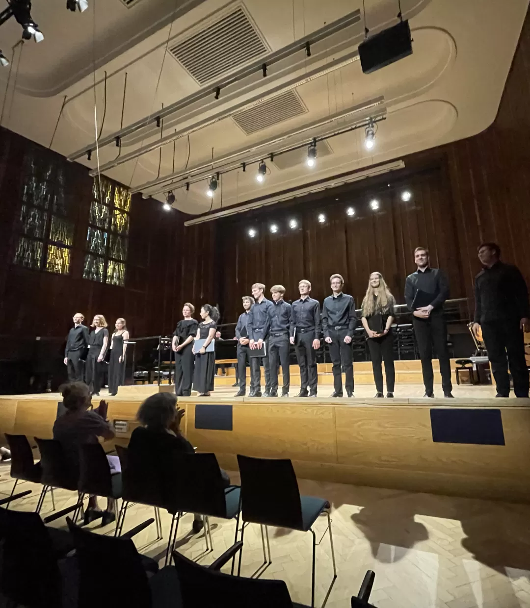 alle Dirgient*innen stehen vorne an der Bühne, Publikum applaudiert