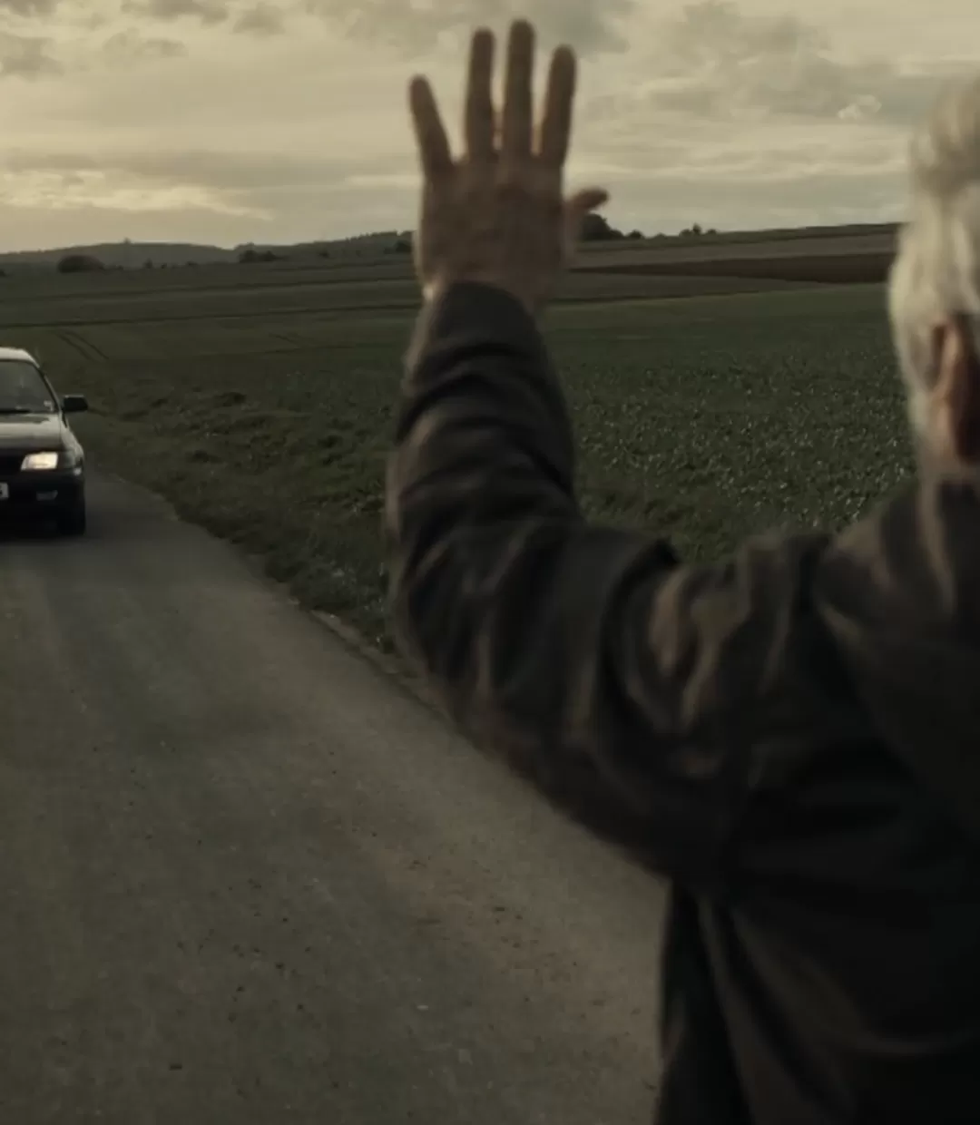 Mann hebt die Hand, um auf der Straße ein Auto anzuhalten.