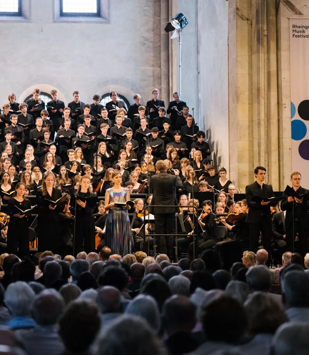 Blick auf volle Bühne mit Chor, Orchester und Solistenoktett im Kloster Eberbach