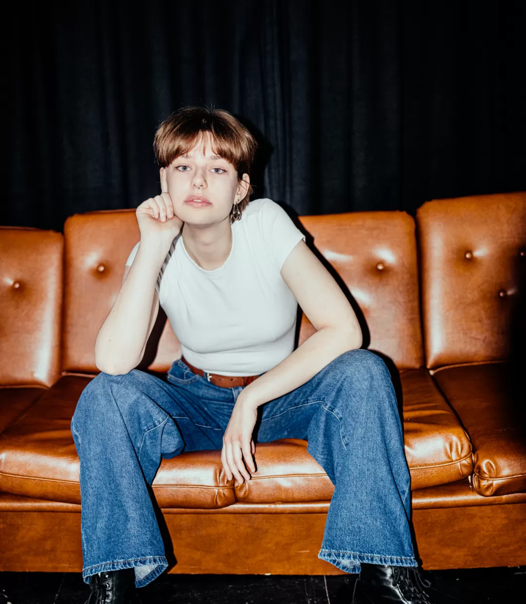 Totale Paula Marie Schulze, weißes T-shirt, blaue Jeans, im Hintergrund eine braune Ledercouch