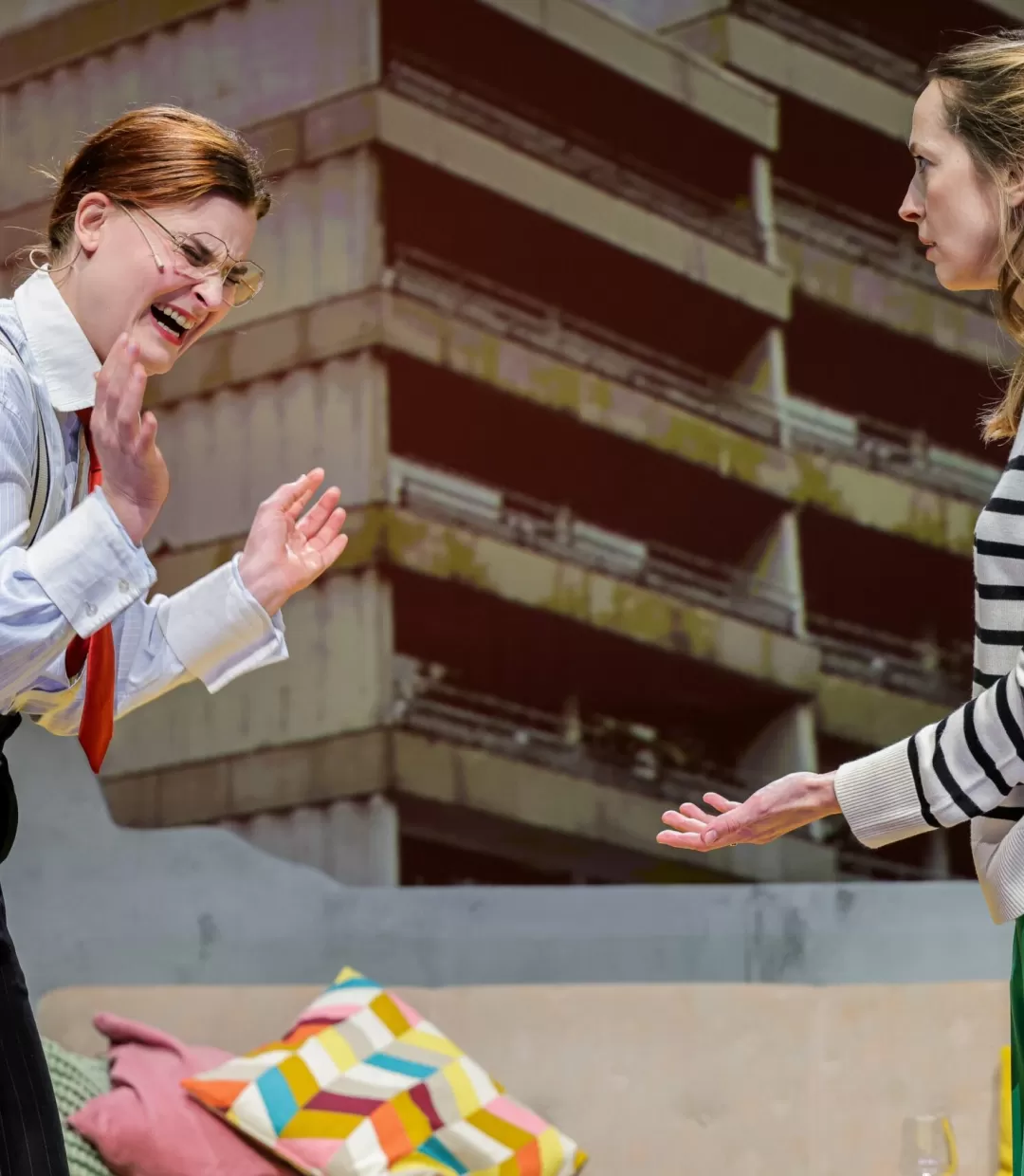 Frau in Hemd mit Krawatte lacht und klatscht in die Hände.