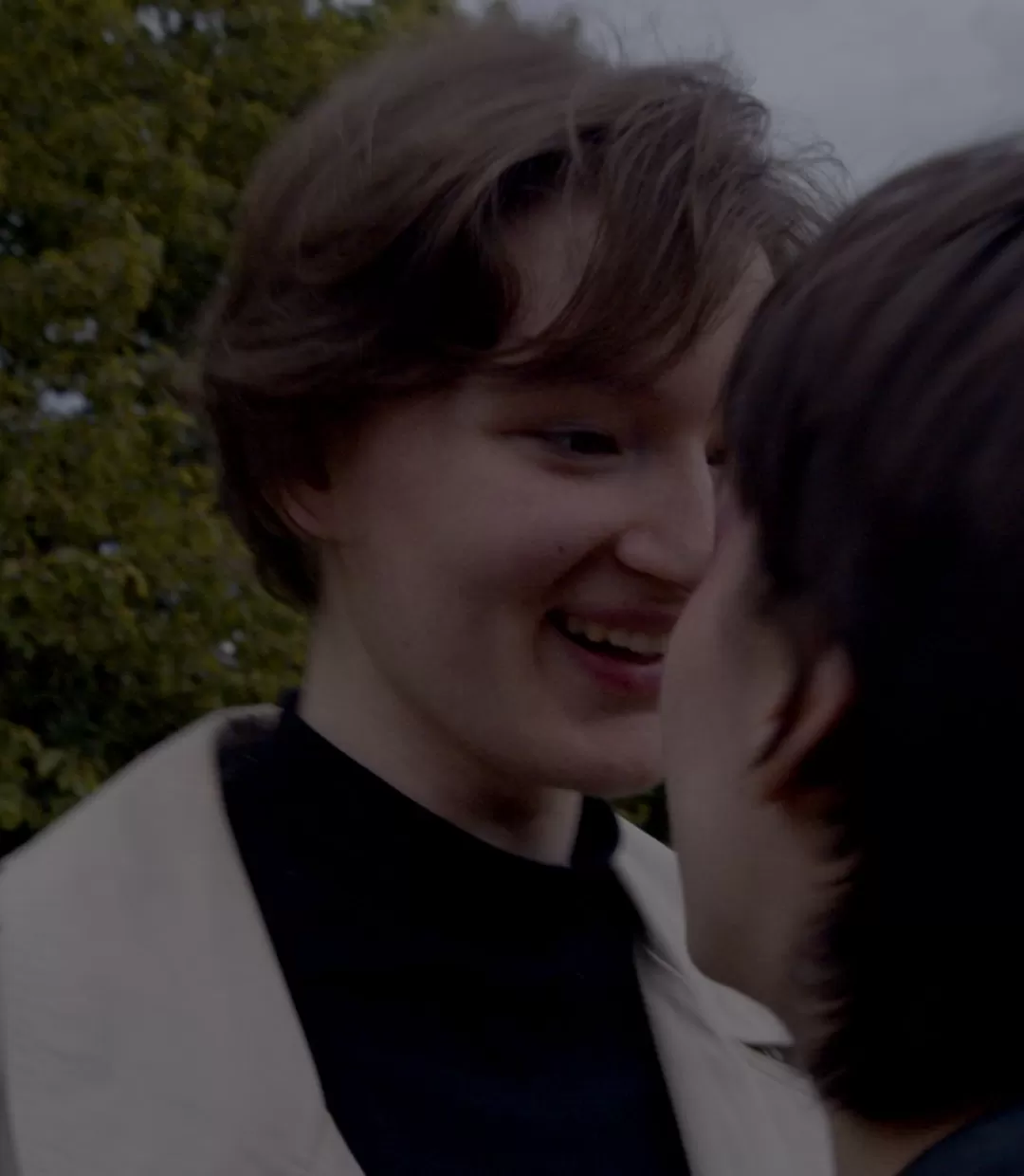 over shoulder shot auf eine Person die lächelt die andere überlegen an