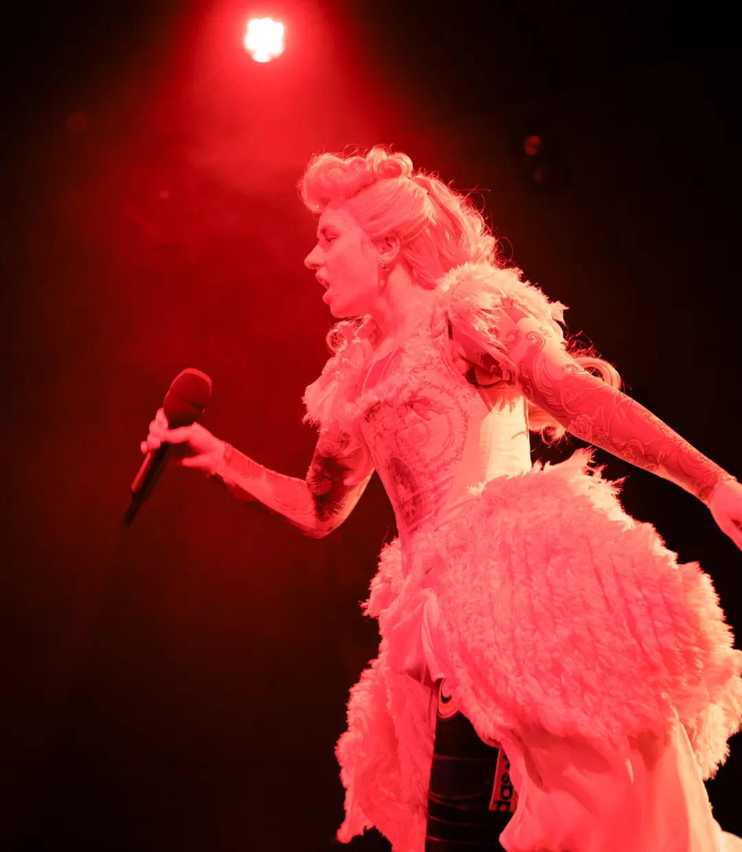 Eine Schauspielerin in Kostüm mit Mikrofon am Singen