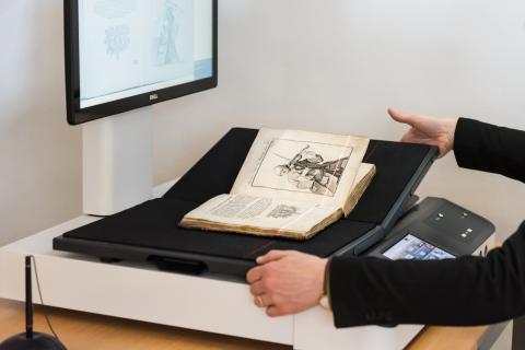 Ein Buch wird von einem Scanner digitalisiert.