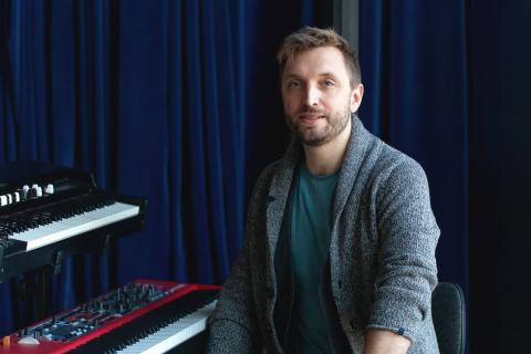 Porträt von Fabian Sennholz neben zwei Keyboards