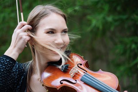 Studentin mit Violine, blonde Strähnen wehen in ihr Gesicht