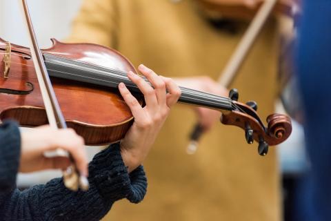 Detailaufnahme einer Hand auf dem Griffbrett einer Viola