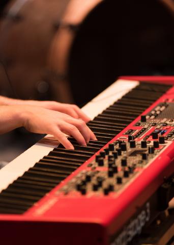 Zwei Hände auf einem roten Keyboard