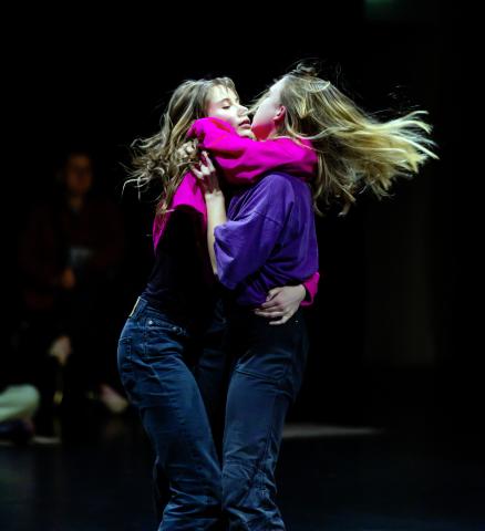 Zwei Tänzerinnen auf der Bühne, die sich umarmen.