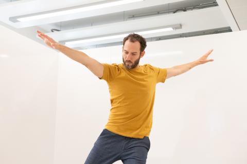 Man in yellow shirt making a pose