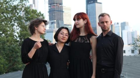 Die vier Musiker*innen des Eunoia Ensembles vor der Skyline Frankfurts
