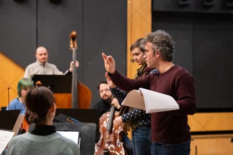 Christoph Altstaedt unterrichtet eine Studentin vor dem Ensemble im Dirigieren