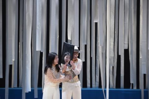 Zwei Musiktheaterdarsteller*innen mit einem Spiegel zwischen ihnen auf der Bühne.