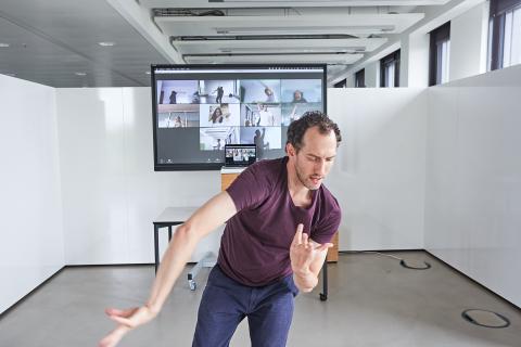man dancing in front of a screen