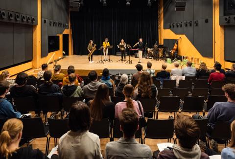 Ein vierköpfiges Studierendenensemble spielt auf der Bühne des Kleinen Saals, im Publikum sitzen Teilnehmende des Infotags Lehramt Musik