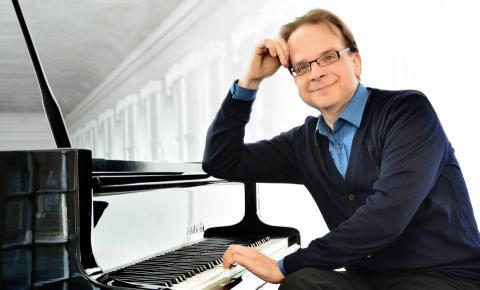 Günther Albers am Klavier sitzend.