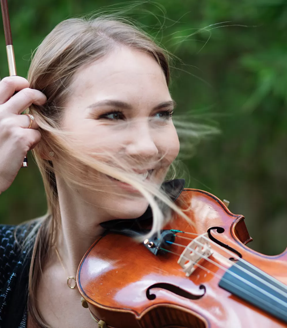 Studentin mit Violine, blonde Strähnen wehen in ihr Gesicht