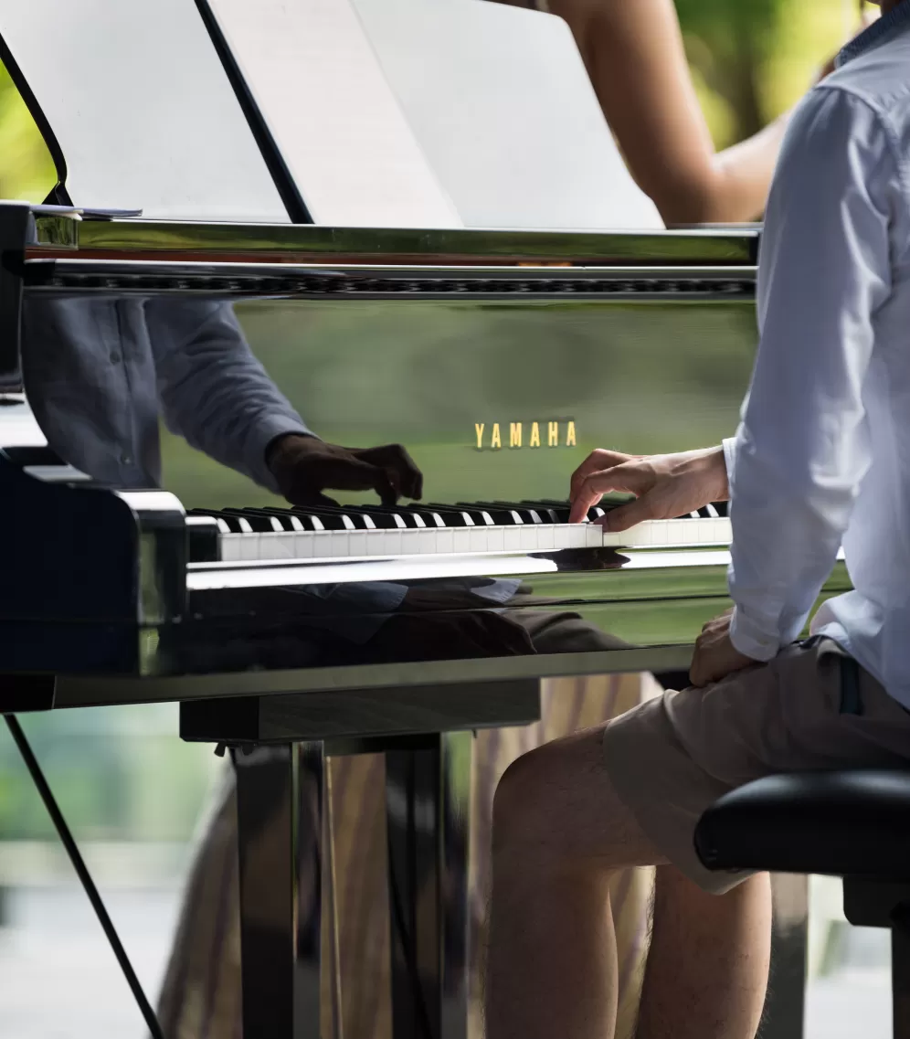 Ein Pianist spielt mit einer Hand auf einem Flügel