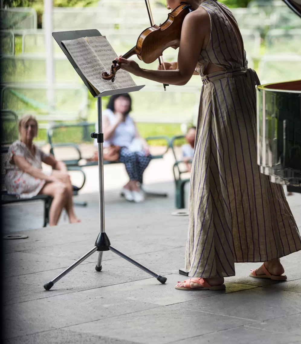 Eine Geigerin auf einer Bühne im Palmengarten.
