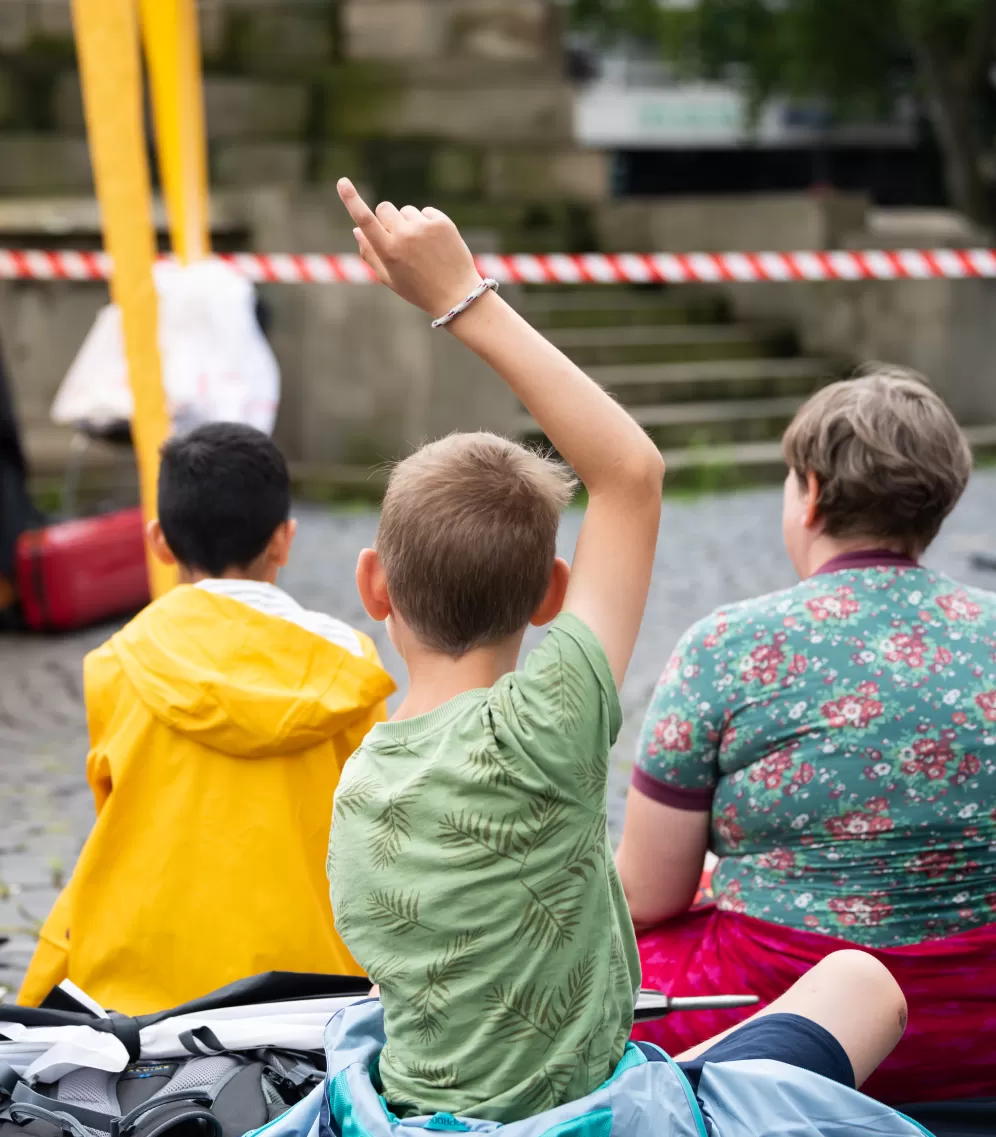 Ein Schüler, der auf dem Boden sitzt, meldet sich