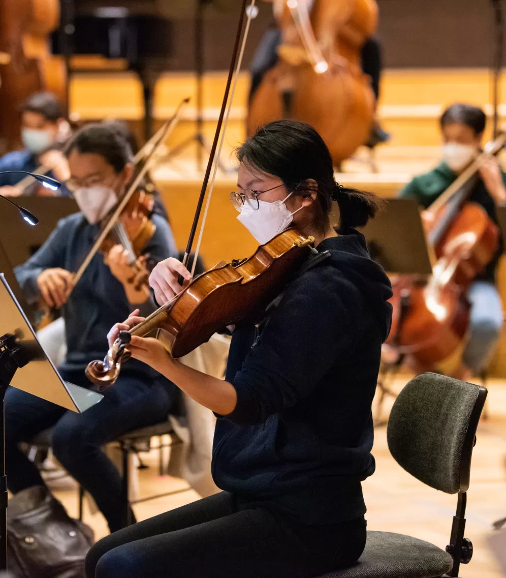 Mehrere Studierende mit Streichinstrumenten im Orchester