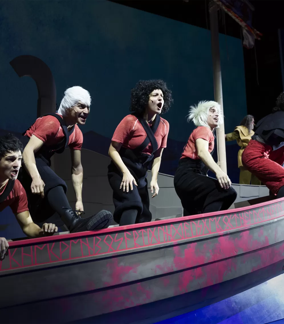 Fünf Schauspieler*innen stehen rufend auf einem Wikingerschiff.