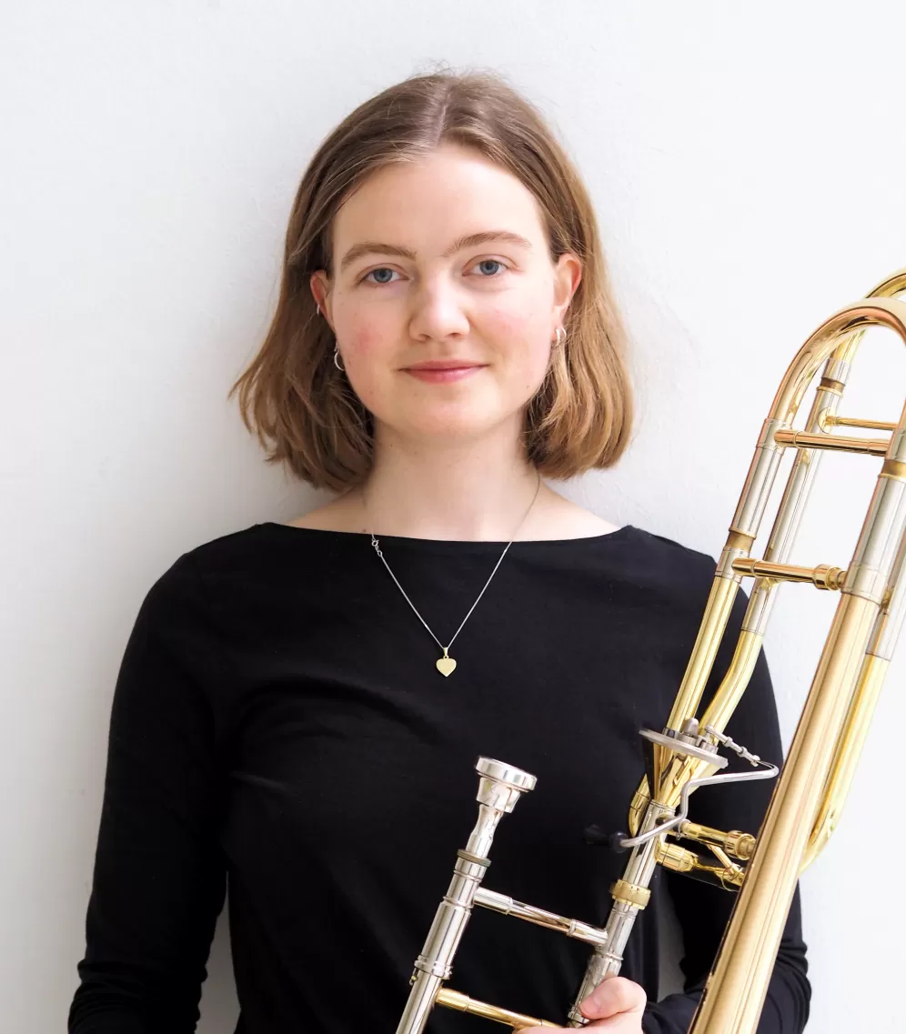 Ruth Externbrink, in die Kamera lachend mit Posaune in der linken Hand