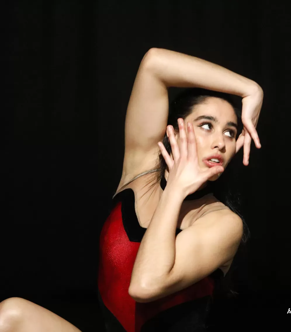 Dancer framing her face with her hands