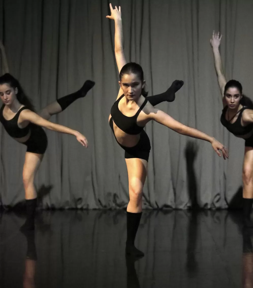 Three dancers in a dance position looking front