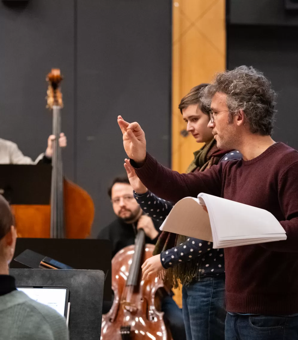 Christoph Altstaedt unterrichtet eine Studentin vor dem Ensemble im Dirigieren