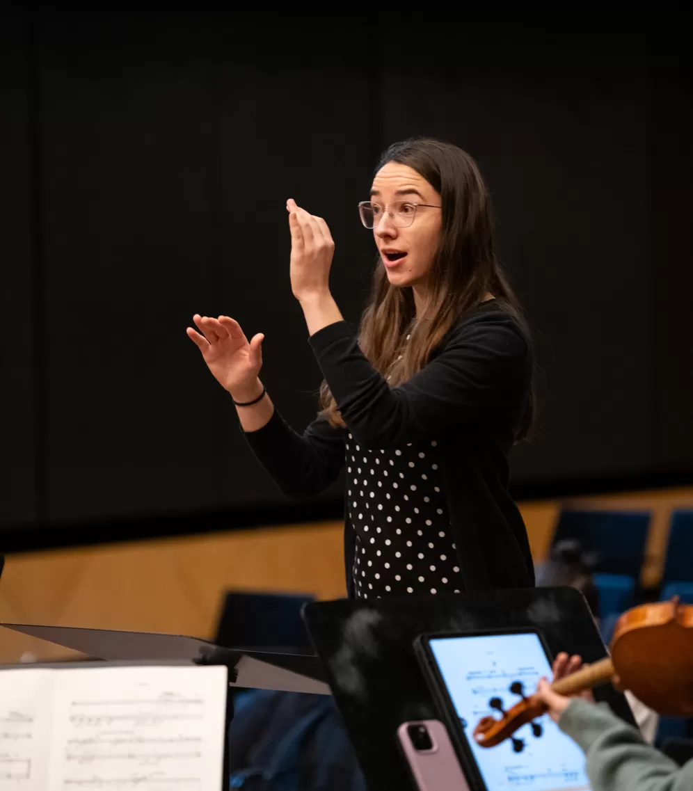 Eine Studentin dirigiert in einer Probe ein kleines Ensemble.