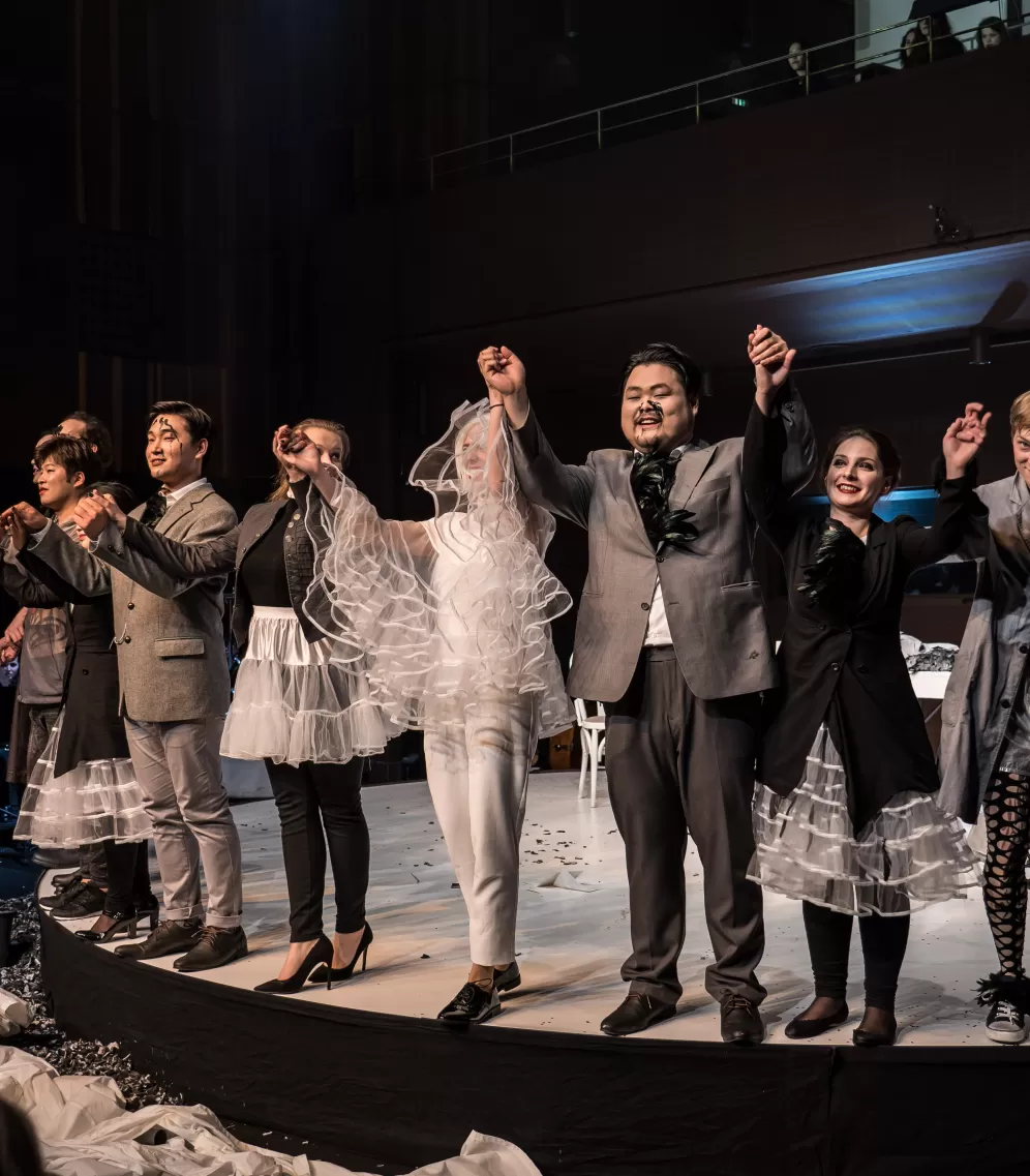 Ensemble einer Opernproduktion beim Applaus auf der Bühne