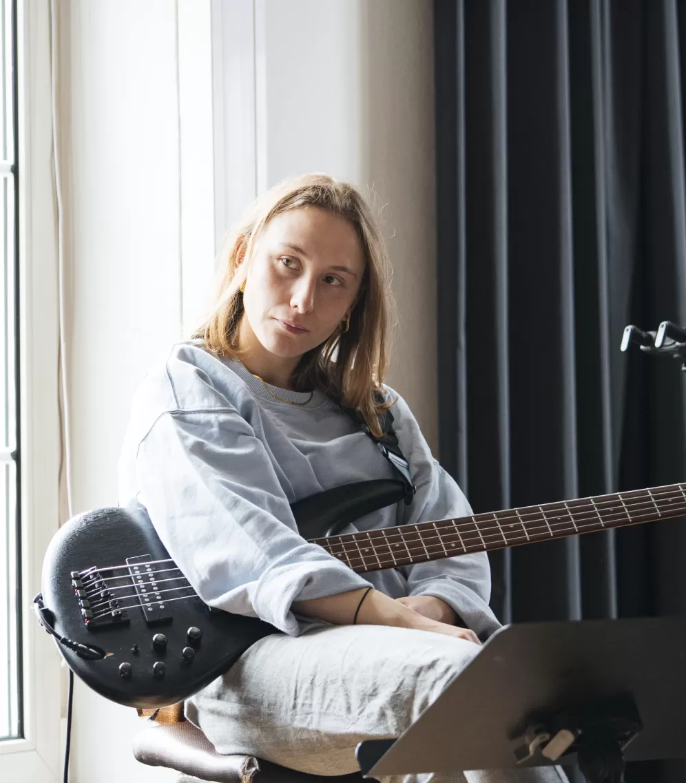 Die Bassistin hört dem Coach zu.