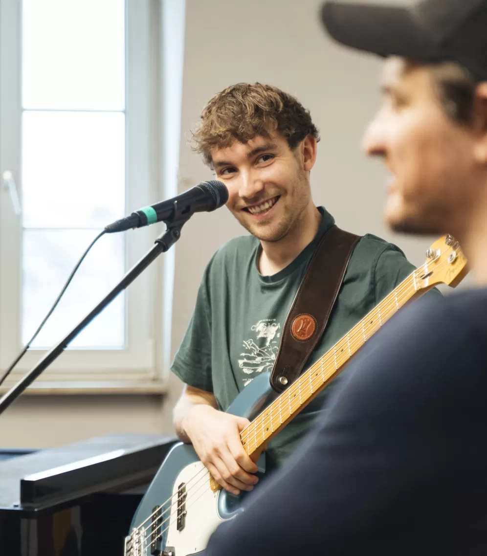 Der Bassist von der Band JAM lächelnd im Coaching