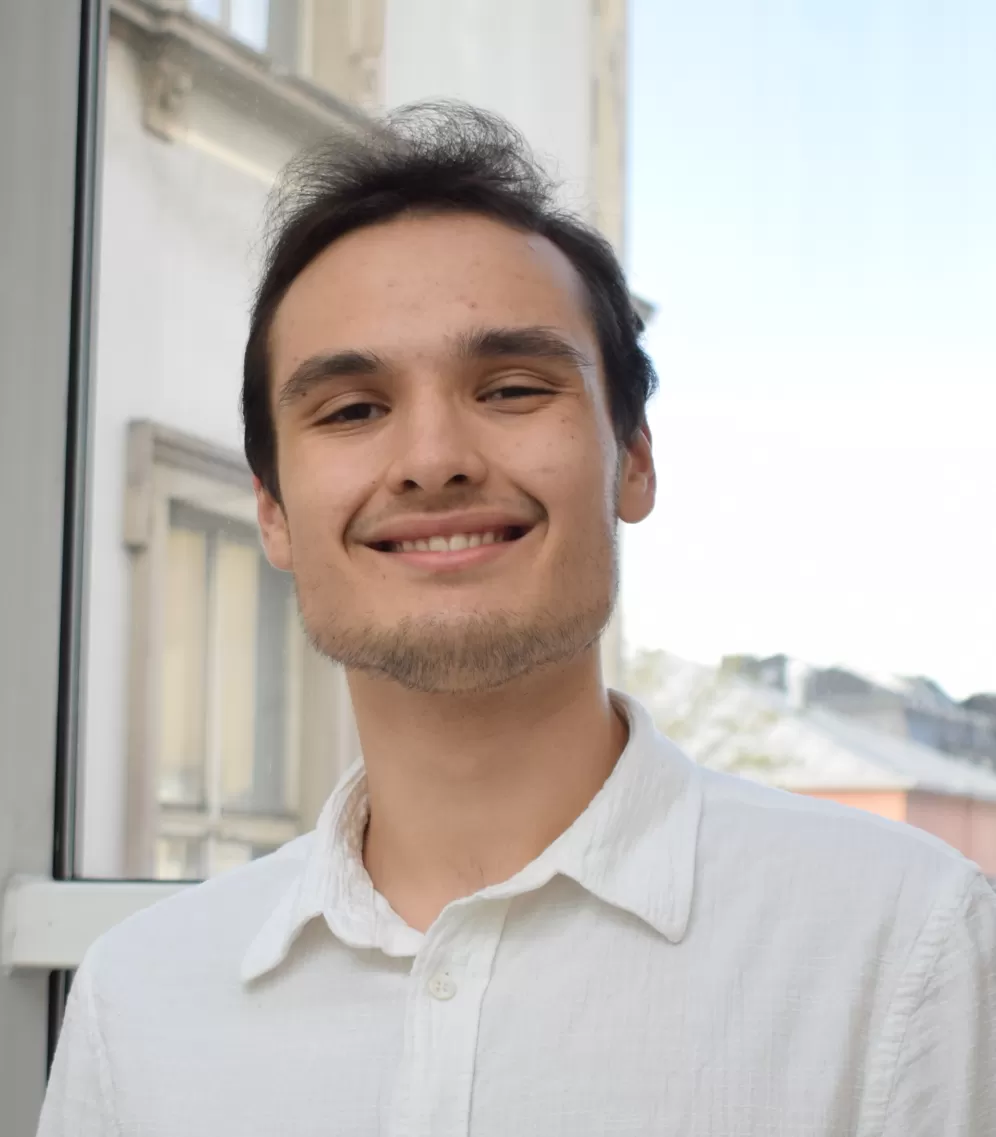 Robin Völbel in der HfMDK vor sonnigem Hintergrund