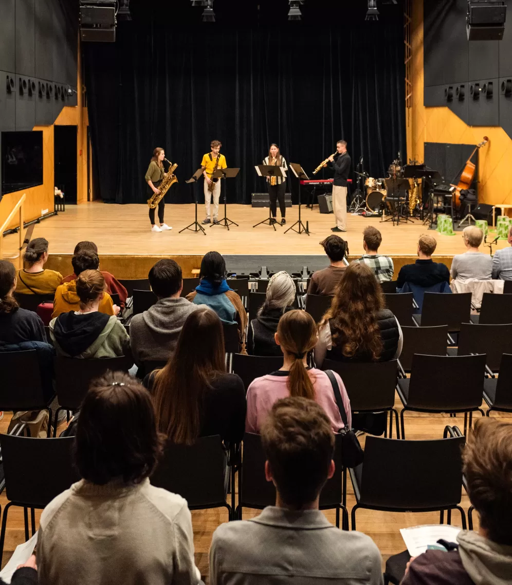 Ein vierköpfiges Studierendenensemble spielt auf der Bühne des Kleinen Saals, im Publikum sitzen Teilnehmende des Infotags Lehramt Musik