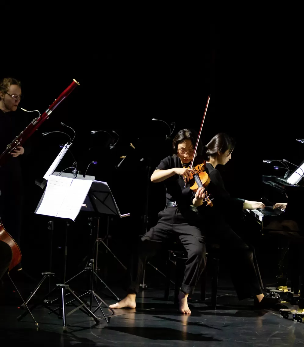 Vier Musiker*innen, barfuß, während einer Performance.