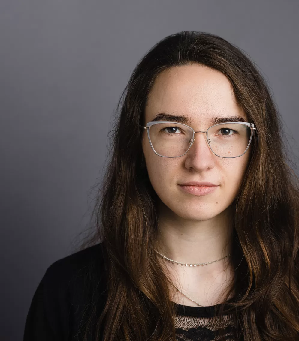 Salome Niedecken schaut vor einem grauen Hintergrund in die Kamera