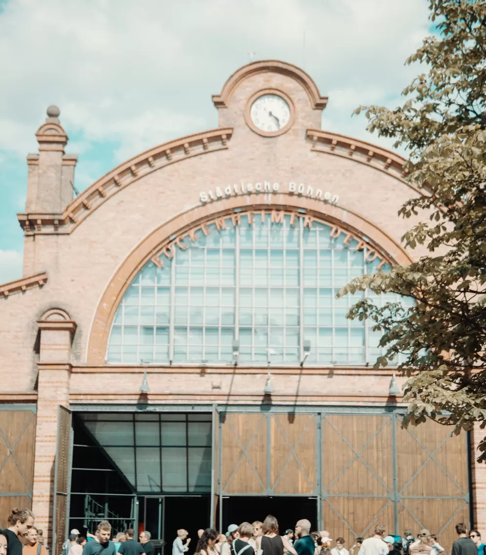 Viele Schauspielstudierende unterhalten sich in kleinen Gruppen auf dem Vorplatz des Bockenheimer Depots.