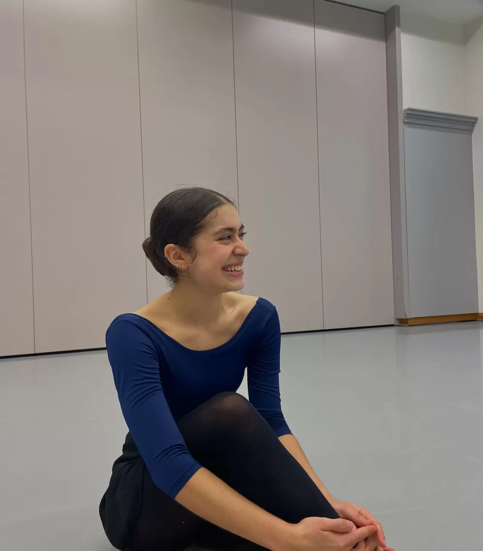Valentina is showing her right profile, wearing a blue leotard and ballet bun