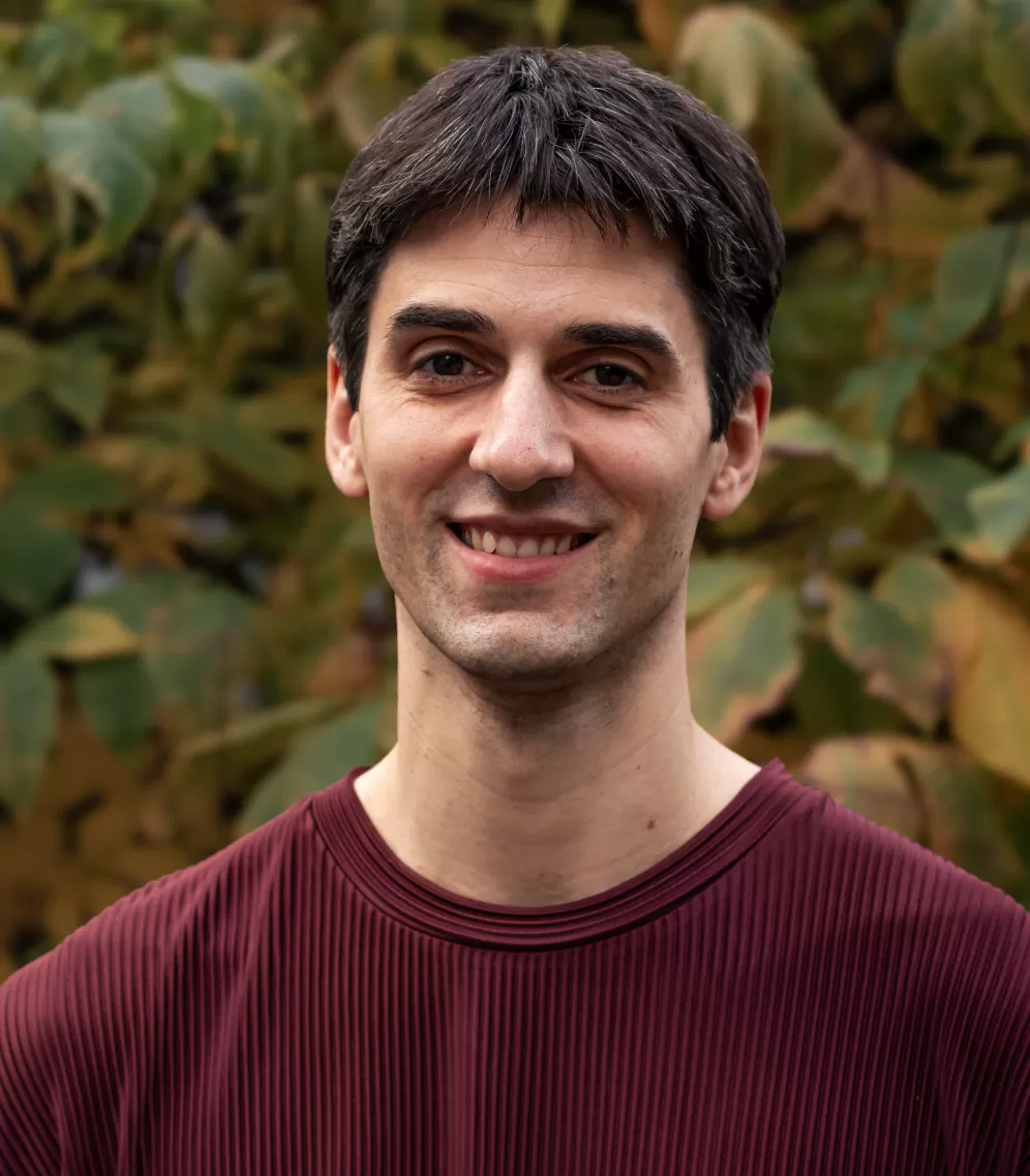 Portrait of a 36 years old man with dark hair and burgundy plissé tshit in 