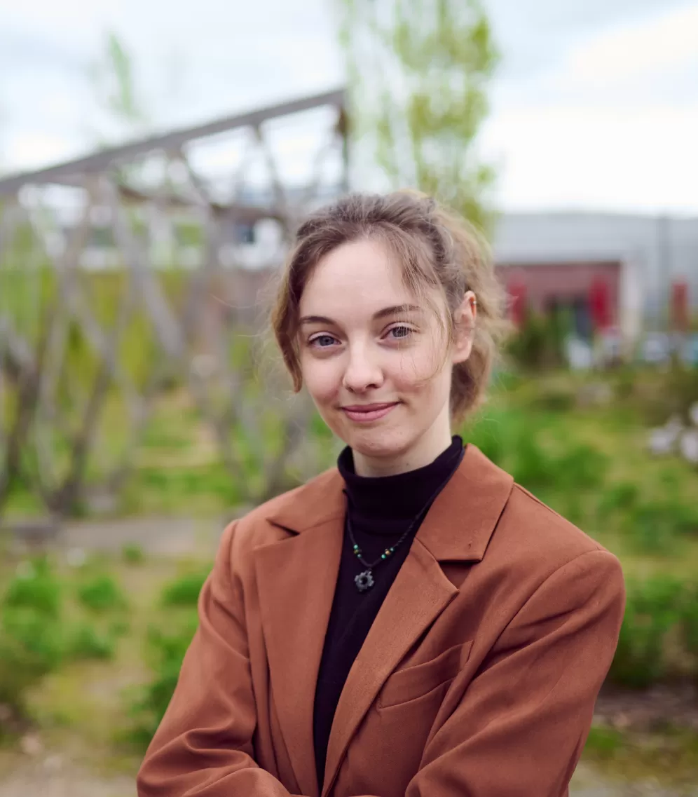 Portraitfoto von Janina Haring vor einem Garten
