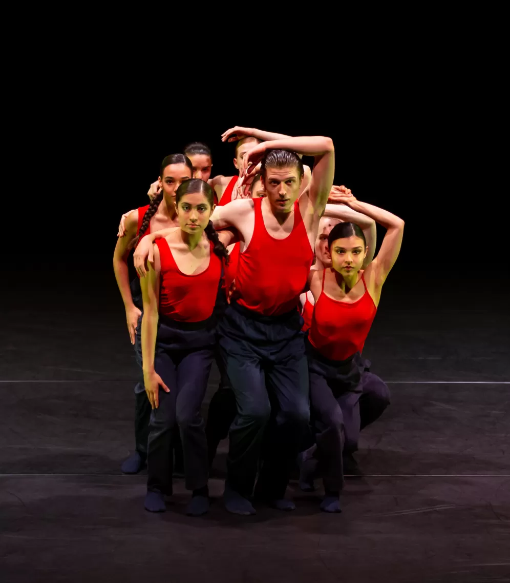 Tänzer*innen posieren als Gruppe auf der Bühne,